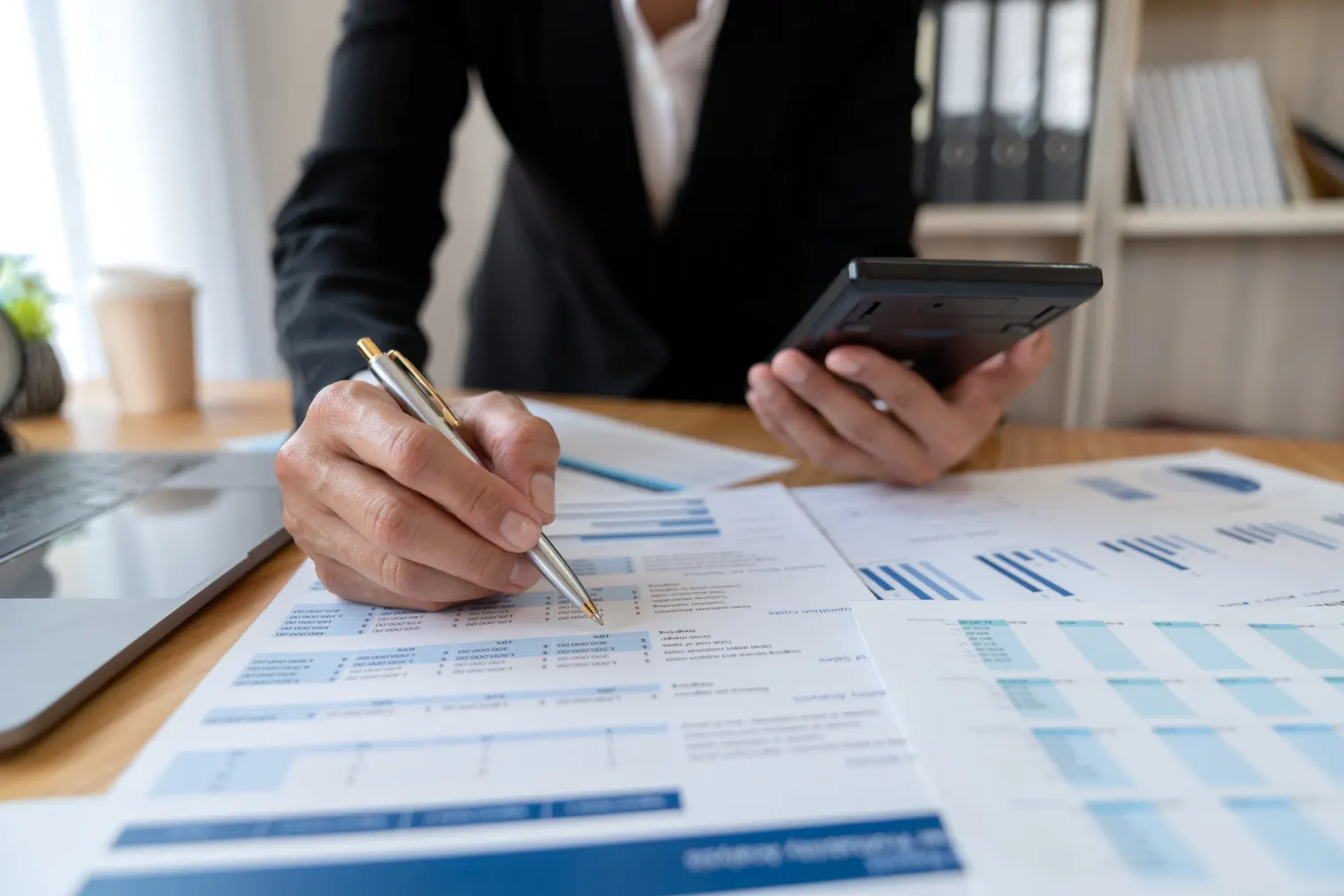 Investisseur étudiant des documents financiers, une calculatrice à la main